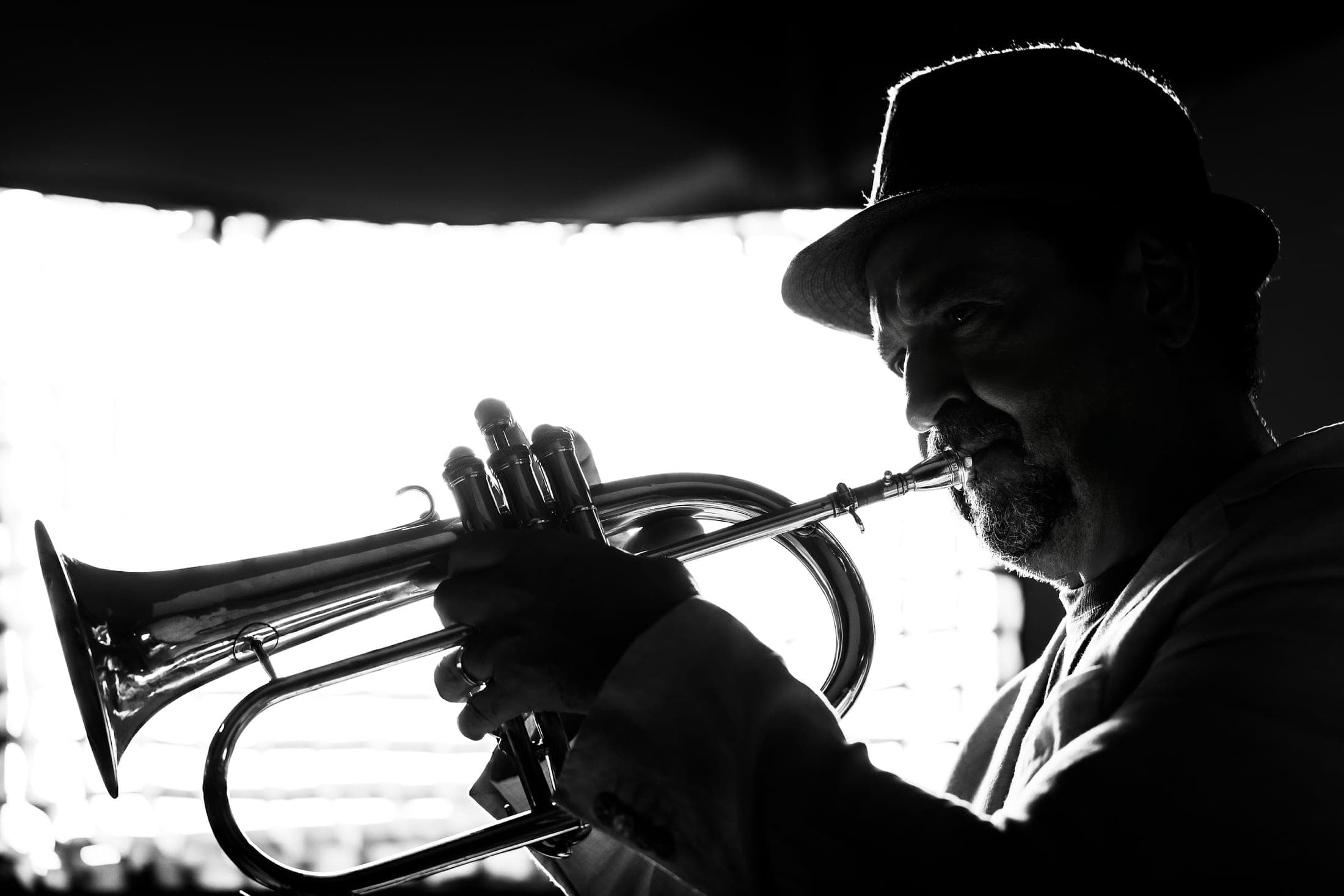 Silvério Pontes em contraluz, tocando flugelhorn, em preto e branco